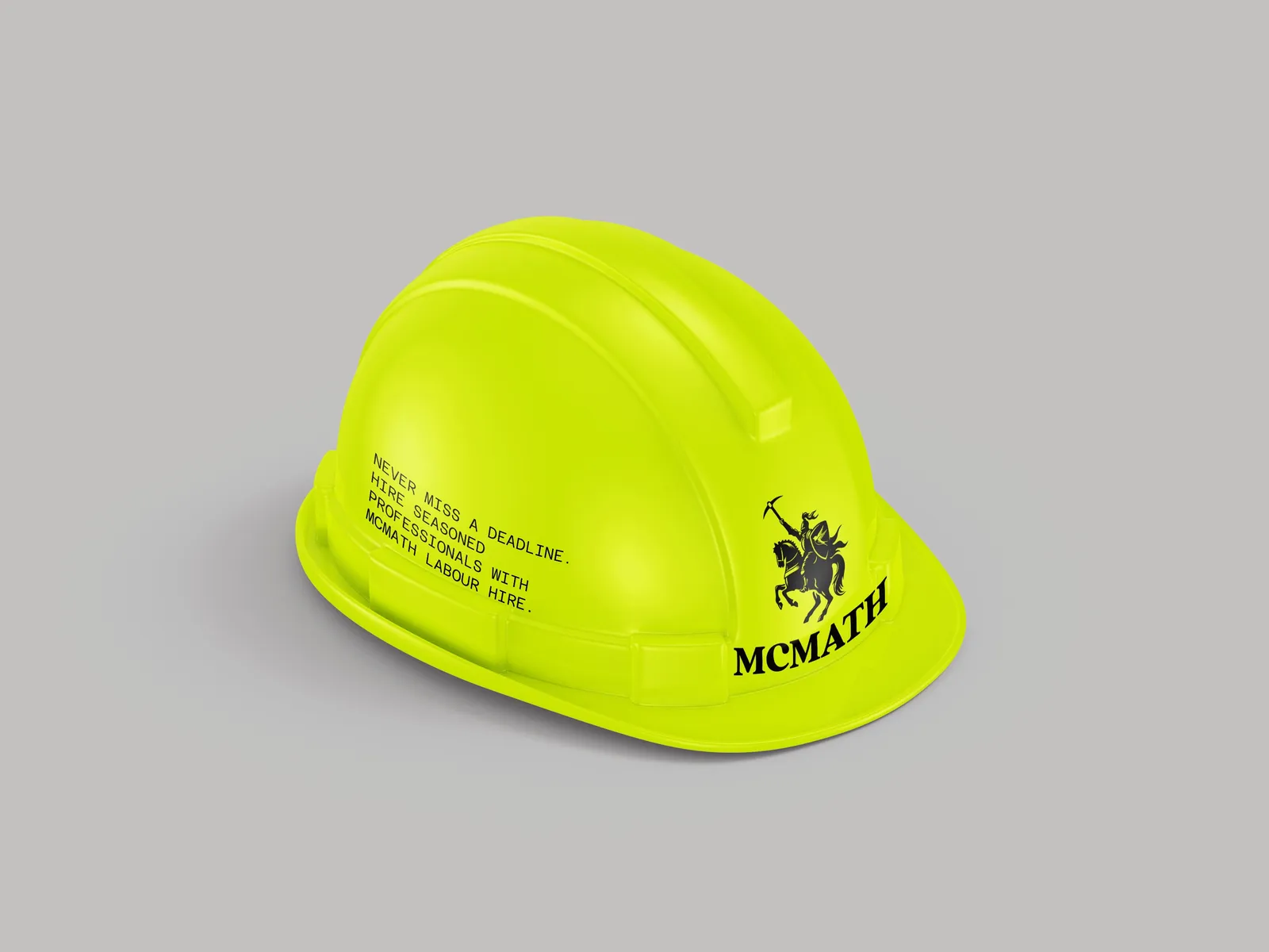 Lime hard hat carrying the McMath mark on the brim and the tagline set in mono on the shell